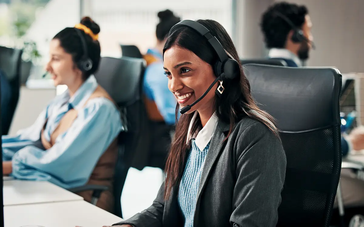 Two support staff wearing headsets in a bright office